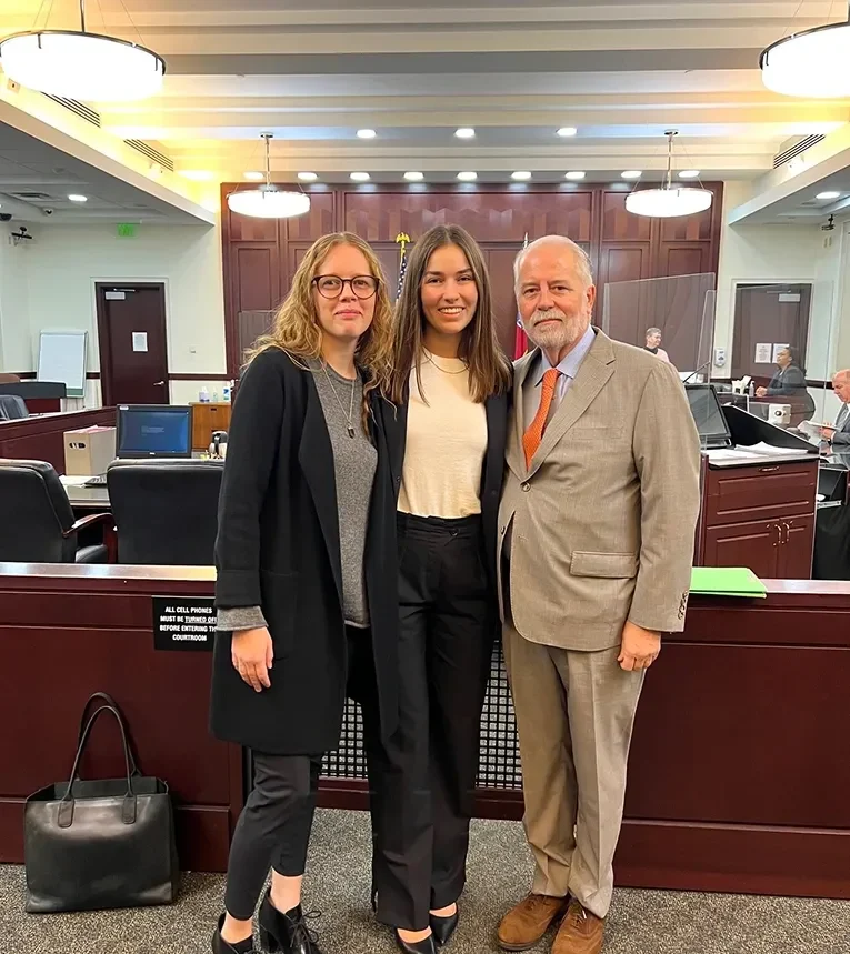 Rob McKinney, Shyanne Riddle, and Savannah Edmonds standing together in a courtroom